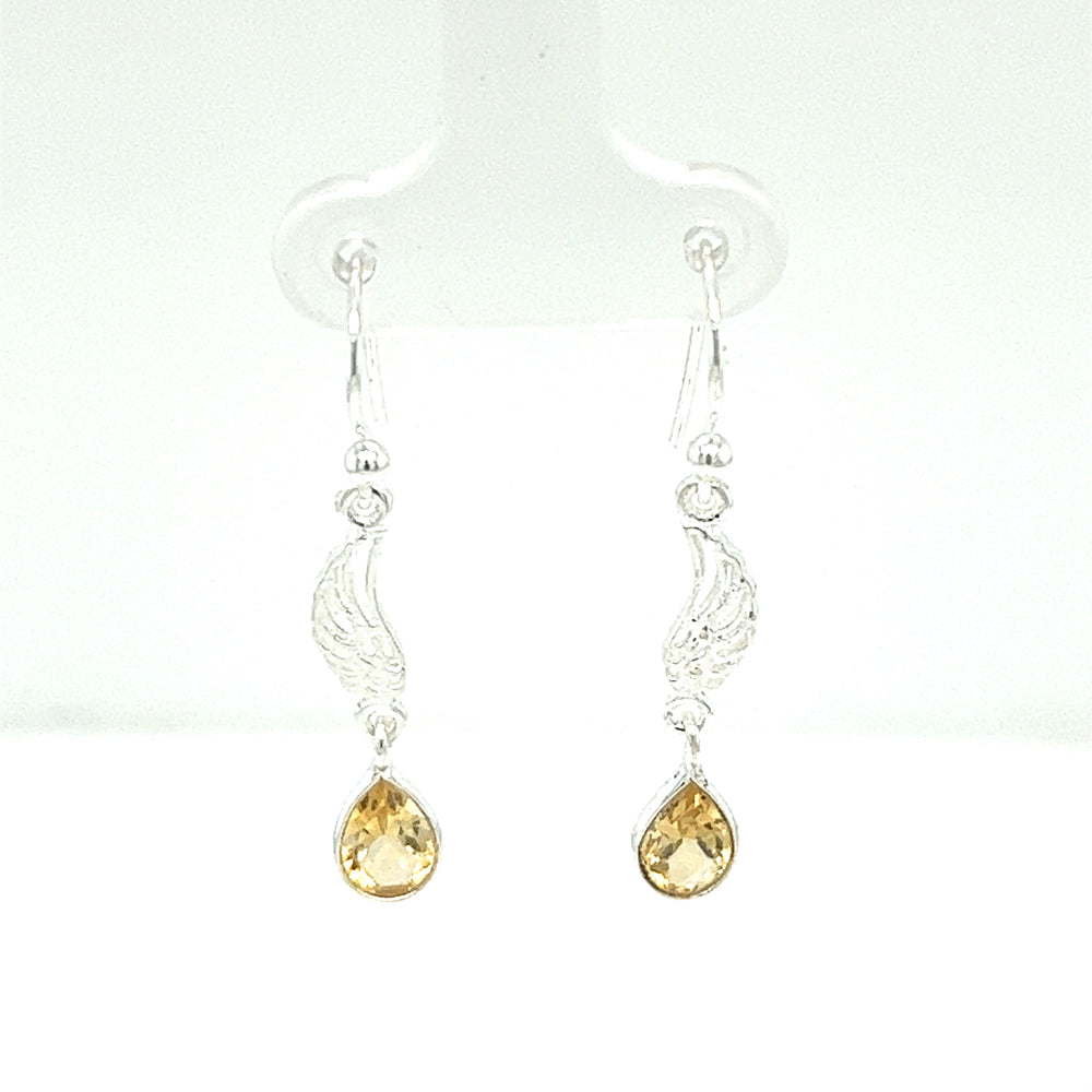 
                  
                    A pair of Super Silver angel wing earrings with citrine stones.
                  
                