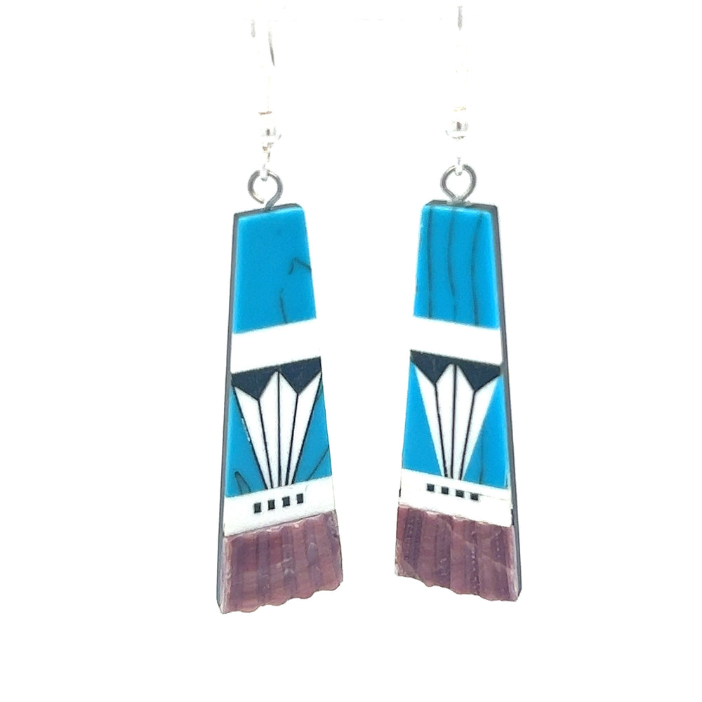 
                  
                    A pair of Super Silver Native American Designed Inlaid Trapezoid Earrings adorned with turquoise and white designs.
                  
                