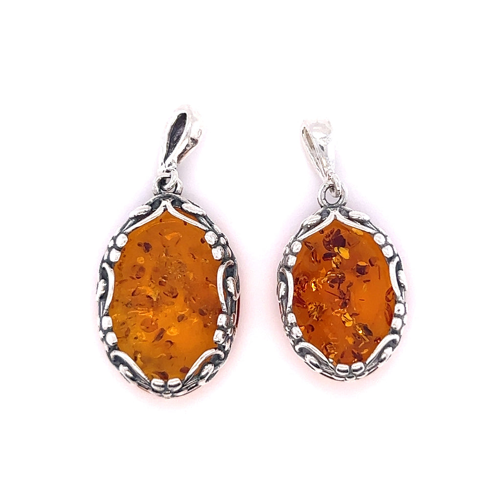
                  
                    A pair of Super Silver Cognac Amber Oval Pendants with Floral Border on a white background.
                  
                