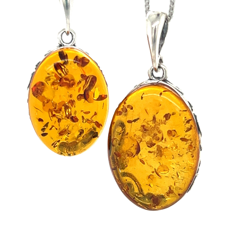 
                  
                    Two Cognac Amber Oval Pendants with Floral Border on a Super Silver chain.
                  
                