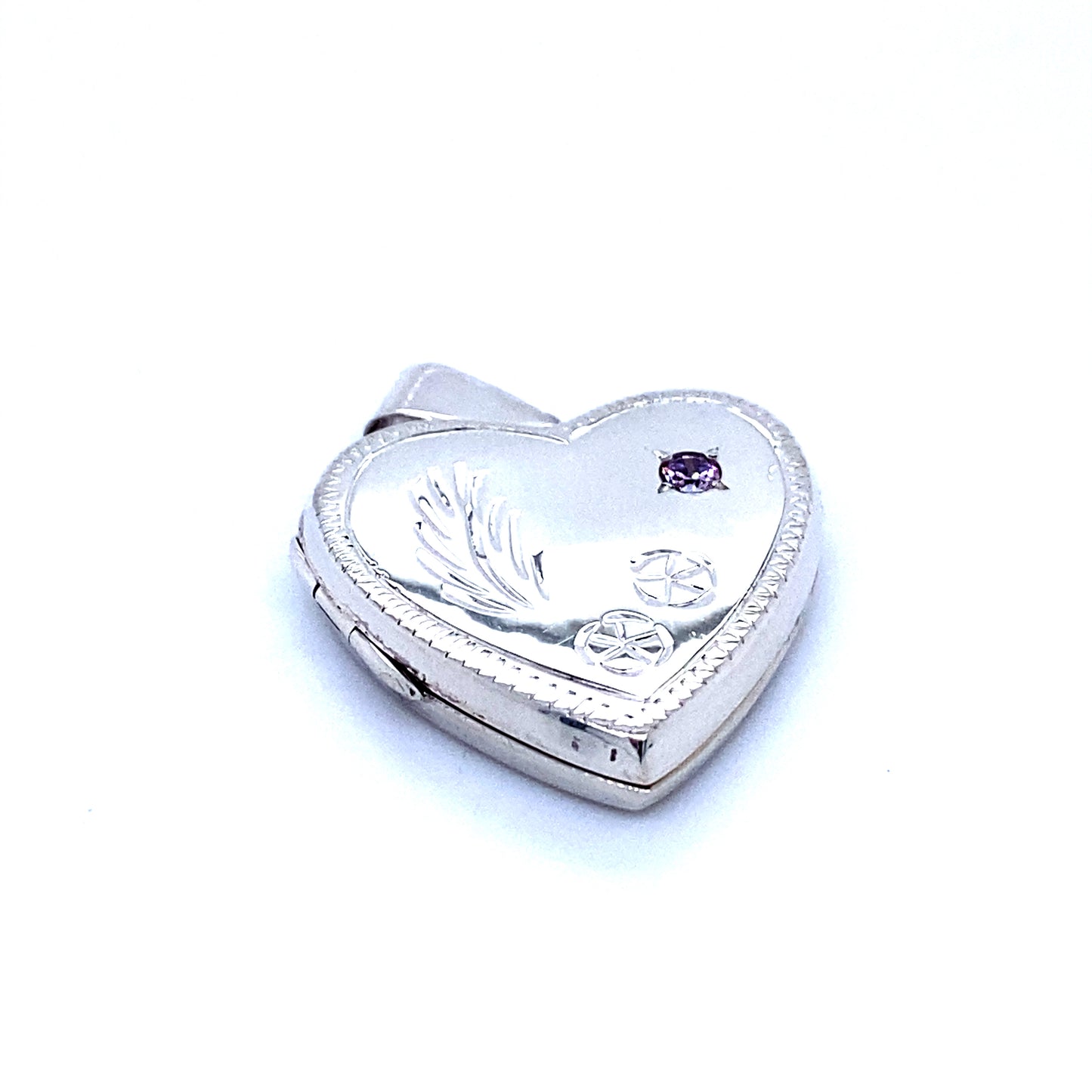
                  
                    A Super Silver Heart Shaped Locket with Stone and lacy Etching with romantic charm and purple stones.
                  
                