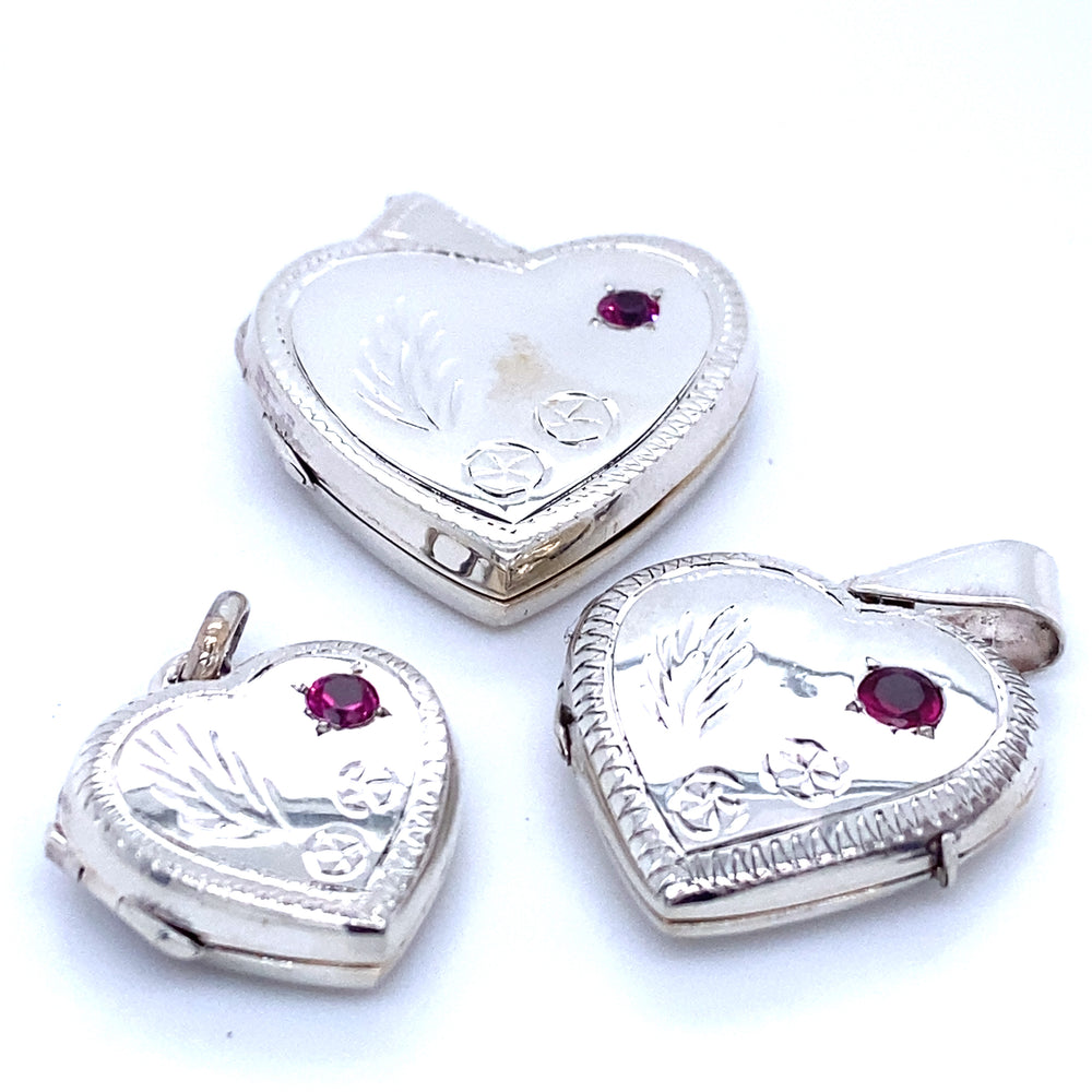 Three Super Silver heart shaped lockets adorned with ruby stones, exuding a romantic charm.