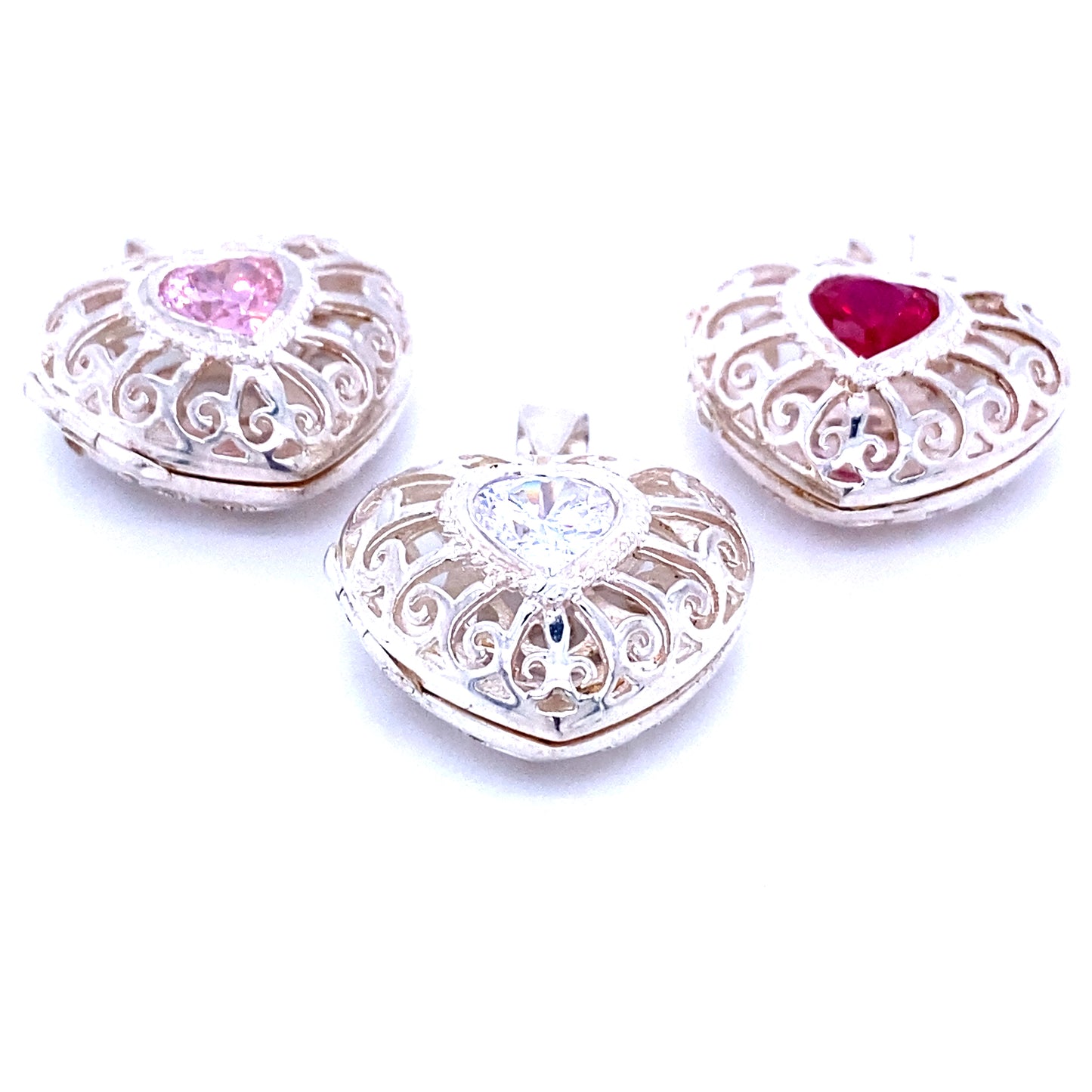 Three Super Silver heart cage lockets with cubic zirconia stones featuring a filigree design.