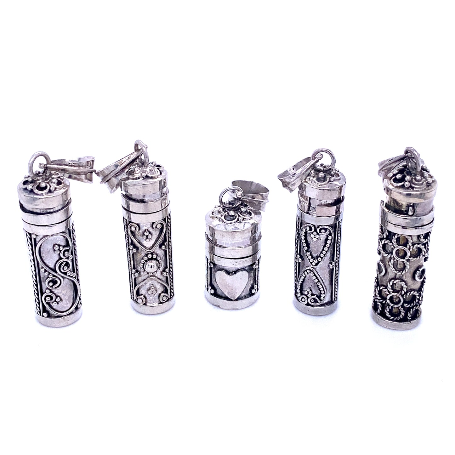 A collection of Super Silver prayer box pendants adorned with hearts, serving as religious mementos.