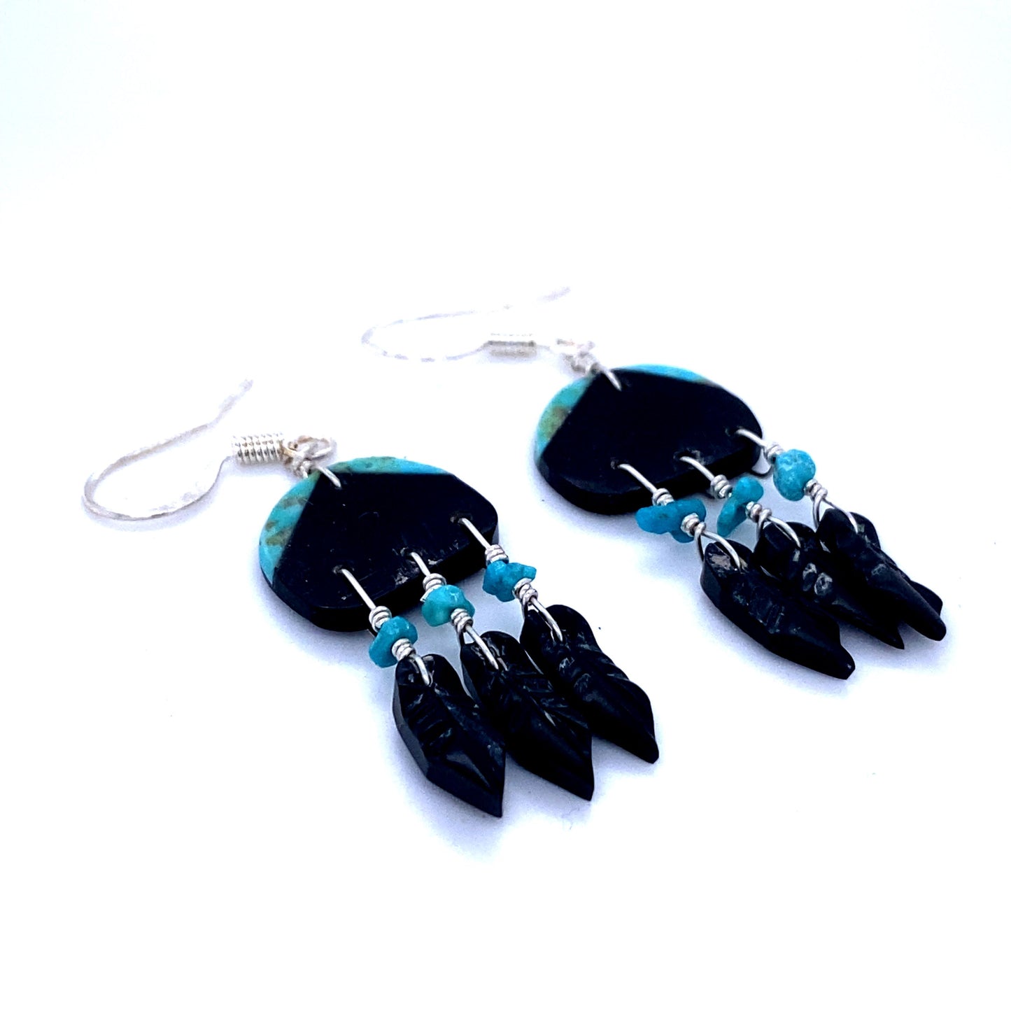 
                  
                    A pair of Super Silver Handmade Earrings with 3 Small Stone Feathers inspired by Native American culture, featuring black and turquoise beads handcrafted by artisans.
                  
                