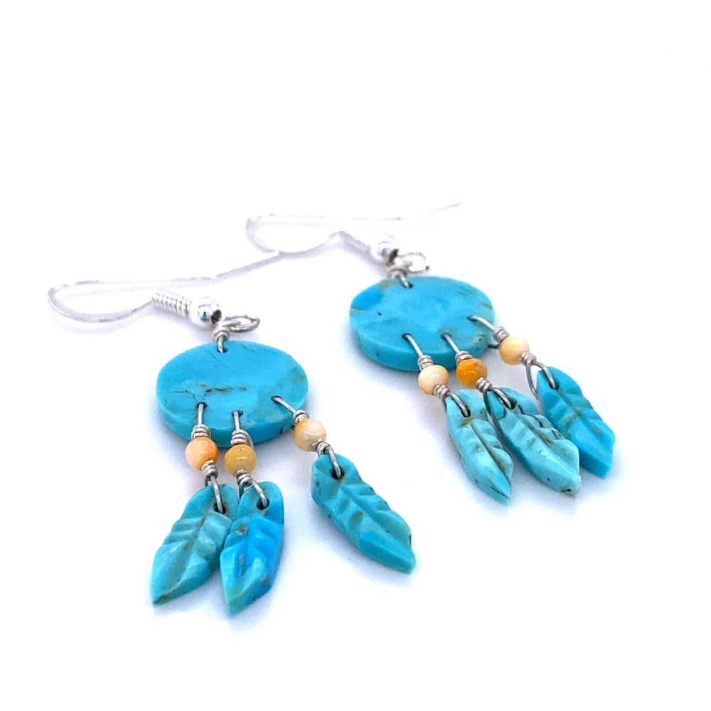 
                  
                    A pair of Super Silver Handmade Earrings with 3 Small Stone Feathers adorned with turquoise beads and delicate feathers, handcrafted by skilled artisans using natural stone.
                  
                