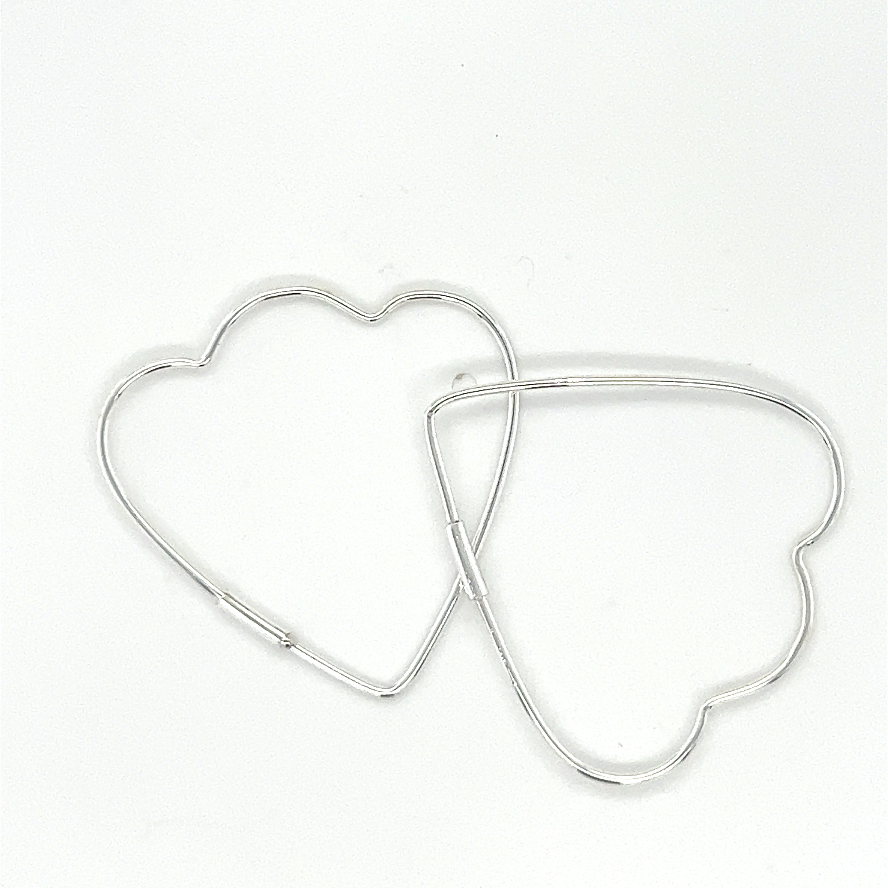 Two Delicate Heart Shaped Hoops by Super Silver on a white surface.