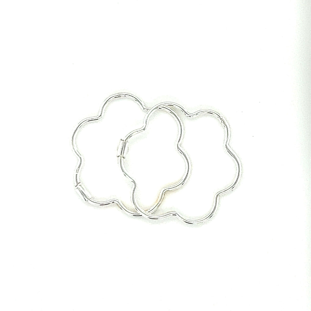 A minimalist Super Silver Delicate Flower Shaped Hoops on a white surface.