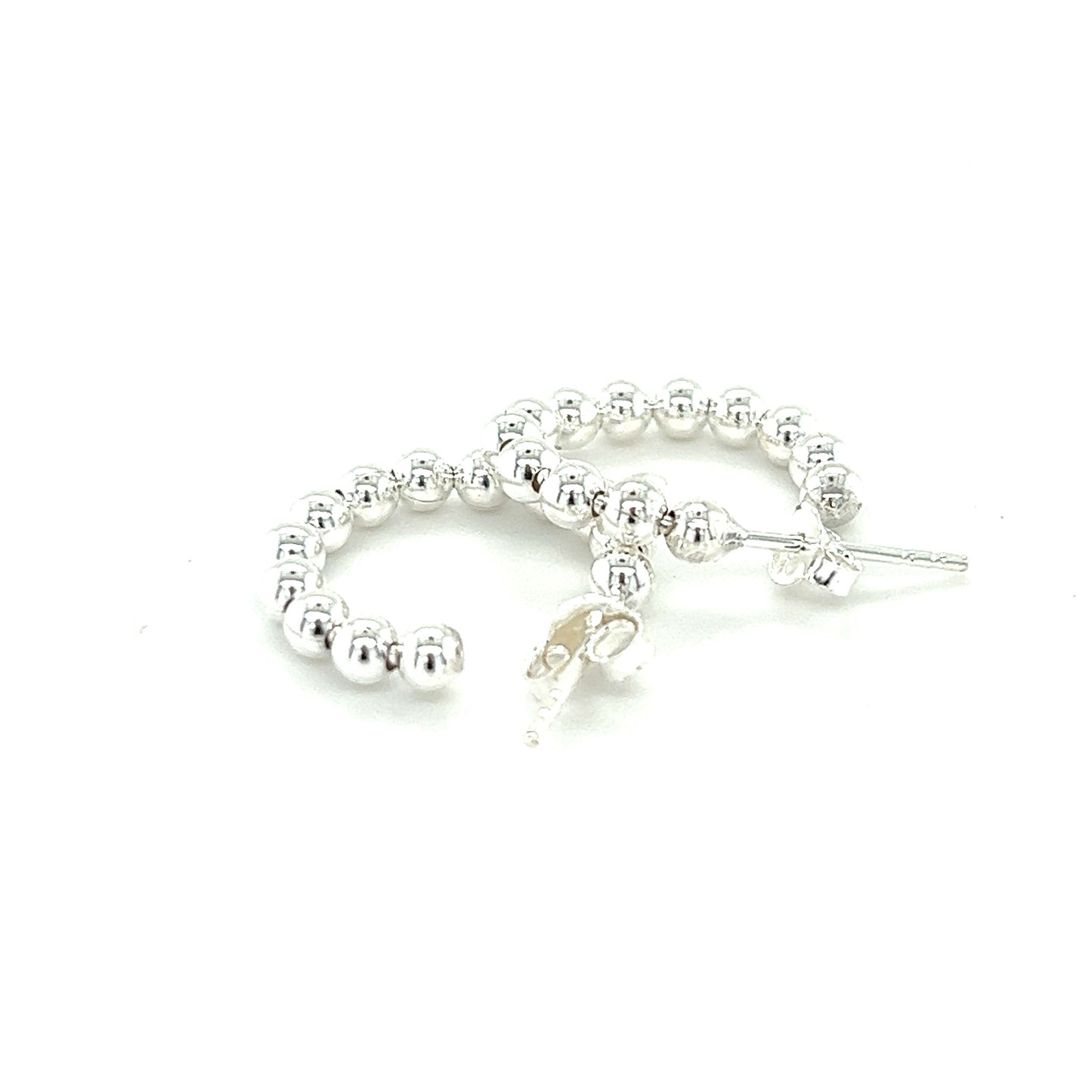 A pair of Delicate Ball Hoops With Post by Super Silver on a white background.