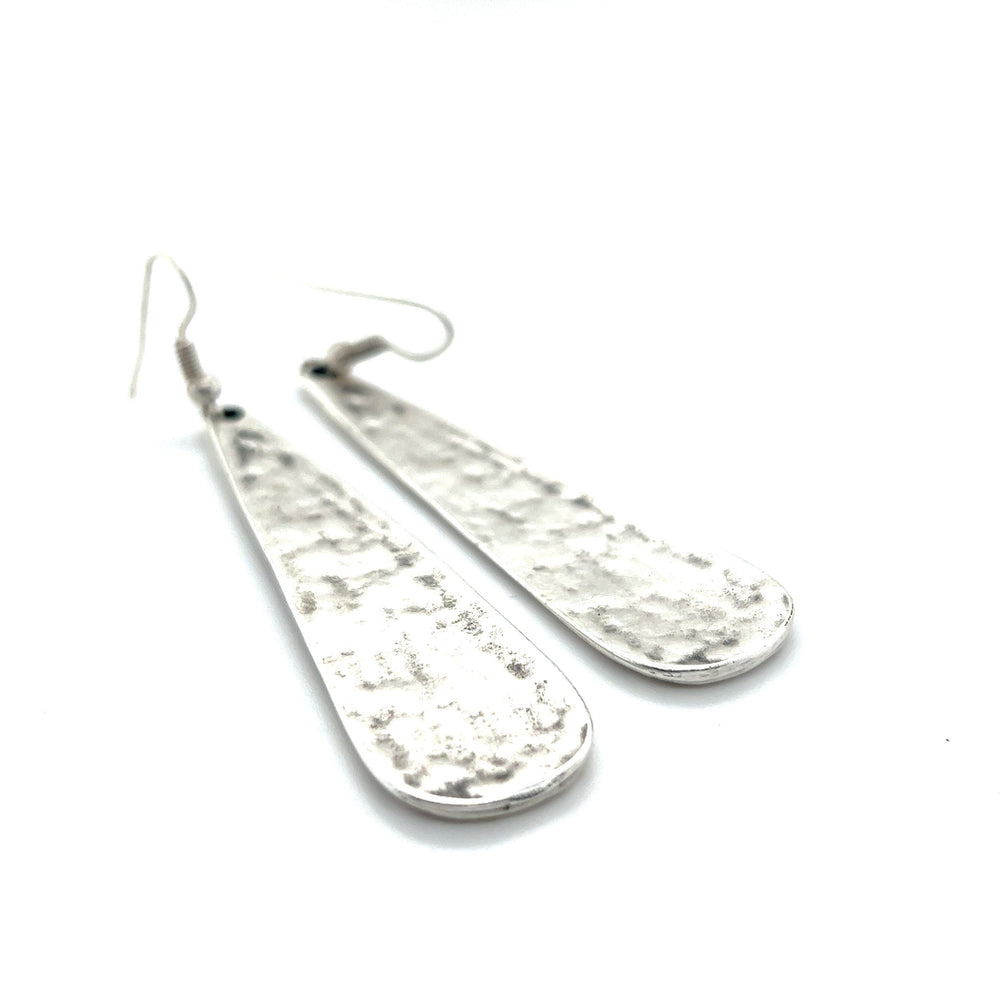 
                  
                    A pair of Super Silver Long Boho Statement Earrings on a white surface.
                  
                
