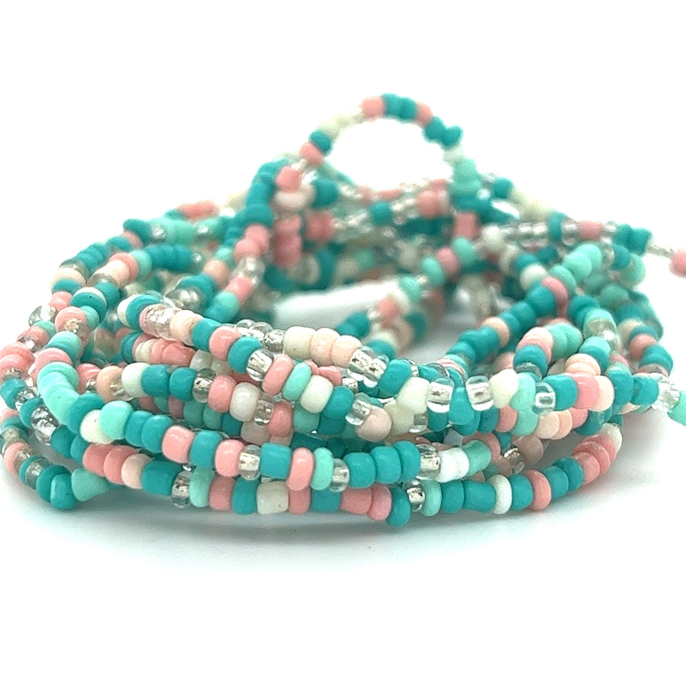 A stack of Super Silver Dainty Beaded Bracelets in vibrant colors.