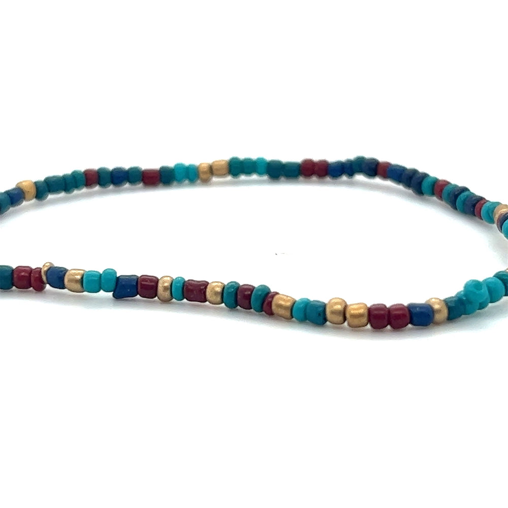 
                  
                    A Super Silver Dainty Beaded Bracelet adorned with vibrant turquoise, red, and gold colors.
                  
                