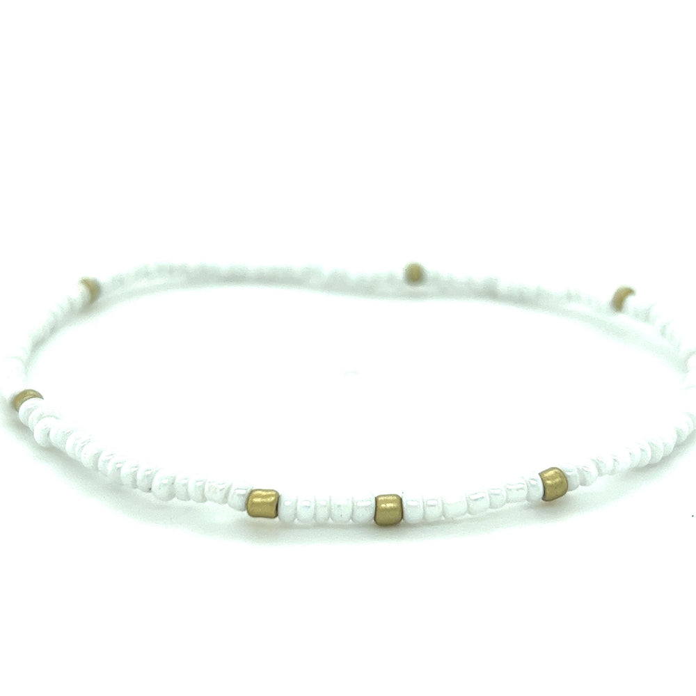 
                  
                    A Super Silver Dainty Beaded Bracelet with gold accents on a white background.
                  
                