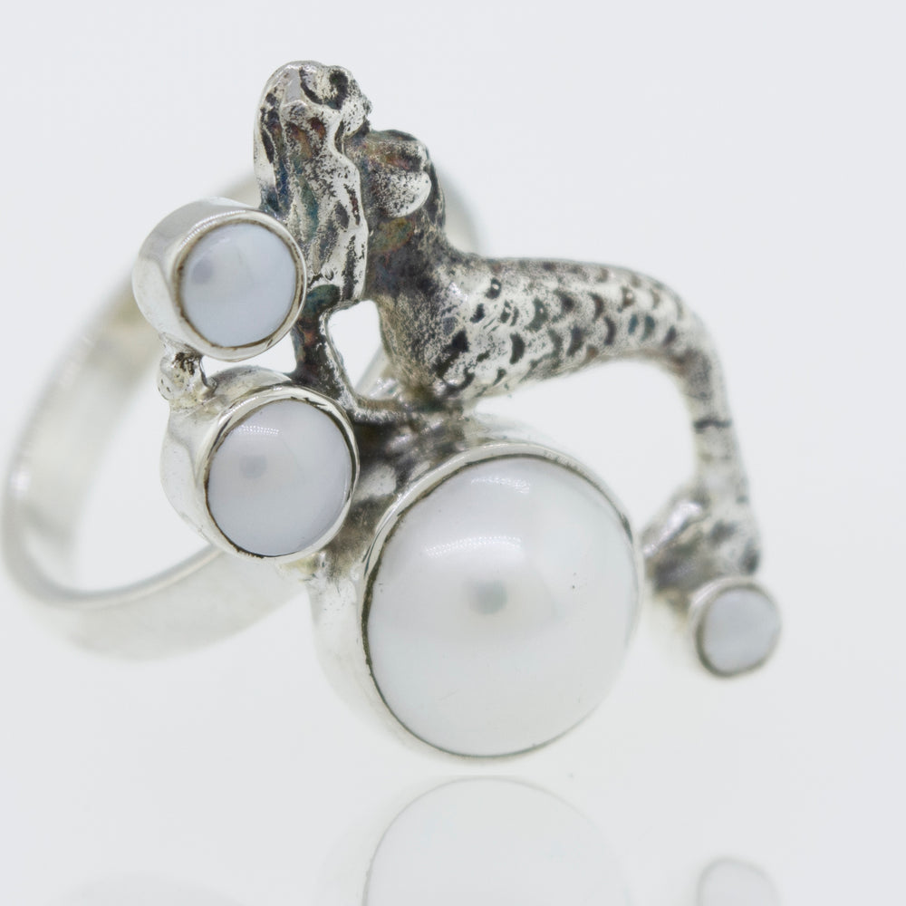 
                  
                    A Mermaid Ring with Pearl adorned with a mythical mermaid and delicate pearls.
                  
                