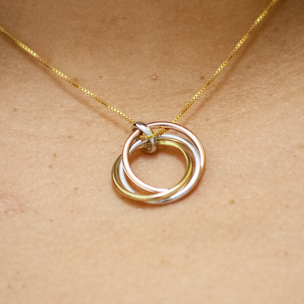 A woman wearing a Simple and Elegant Gold and Rose Gold Plated Pendant with a three ring pendant from Super Silver.