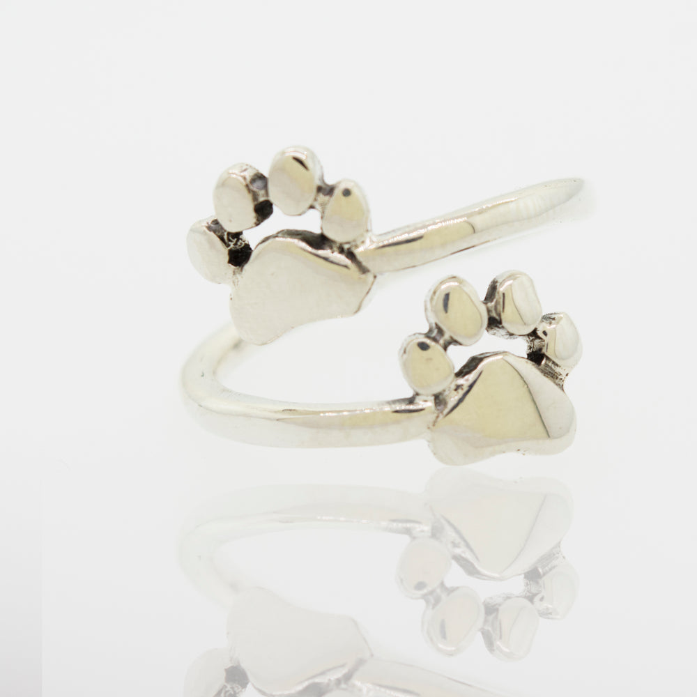 A cute Super Silver Dog Paw Print Adjustable Ring with two dog paw prints on it.