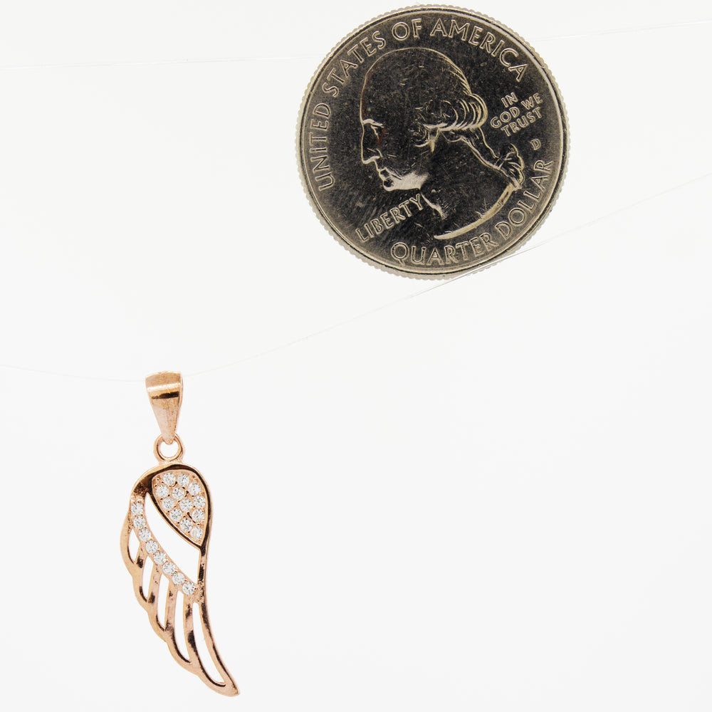 
                  
                    A Super Silver cubic zirconia feather-shaped pendant adorned with a feather, next to a penny.
                  
                