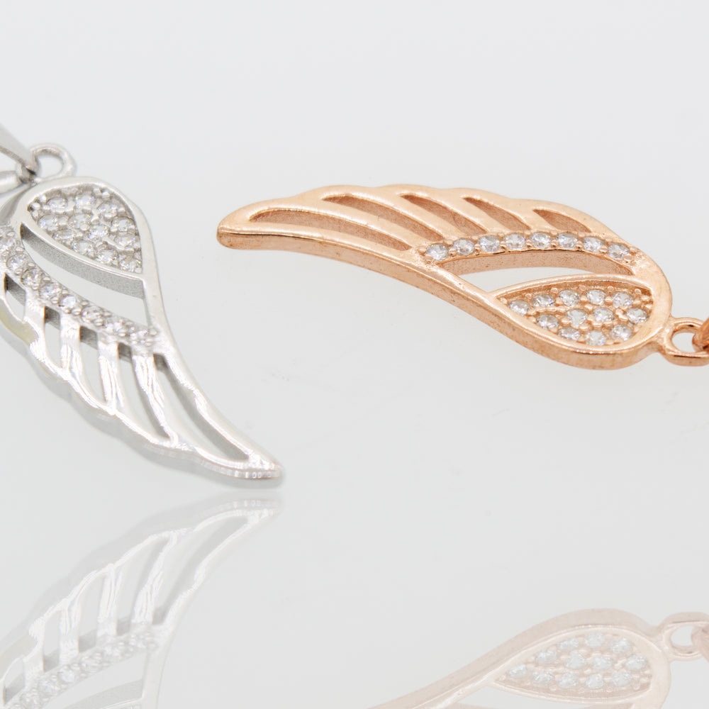 
                  
                    Two Super Silver Cubic Zirconia Feather Shaped Pendants in rose gold and white gold with feather accents.
                  
                