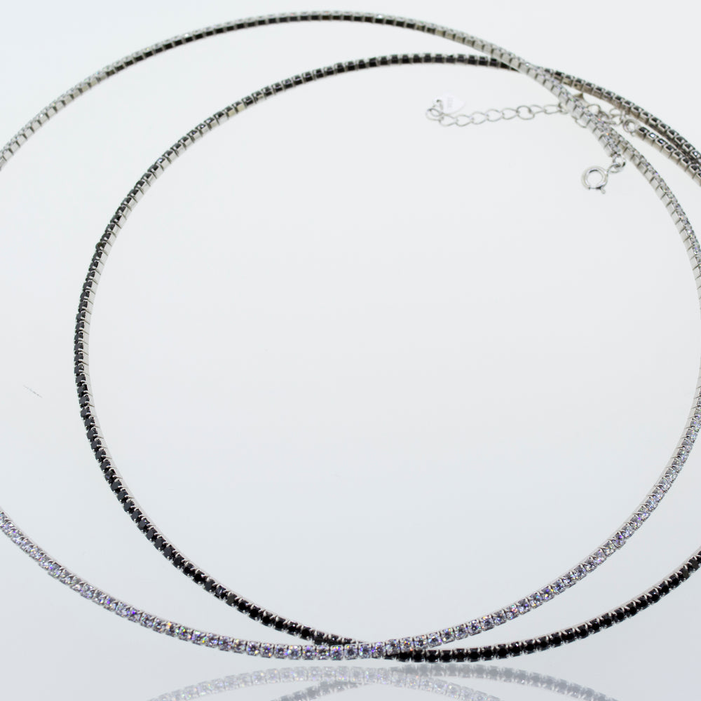 
                  
                    A pair of Super Silver cubic zirconia tennis necklaces with cubic zirconia stones on a white surface.
                  
                
