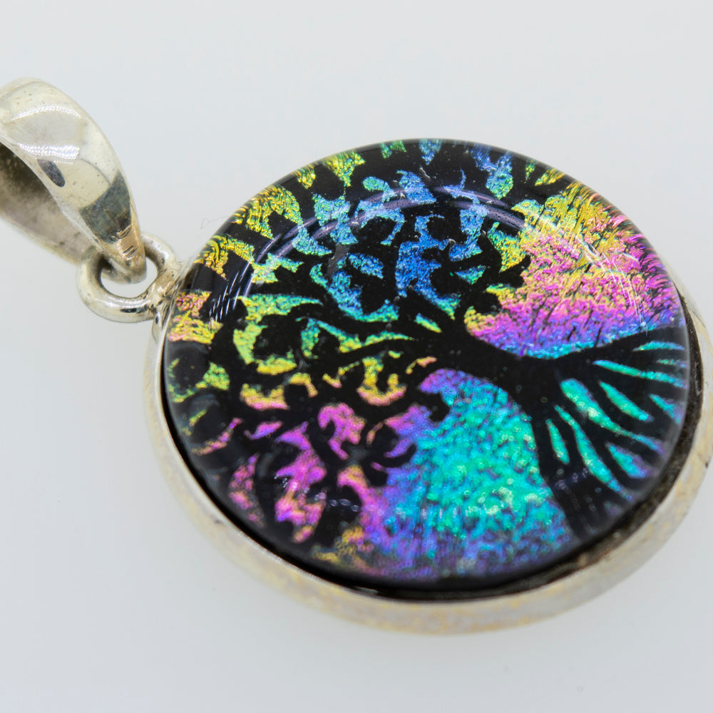 A colorful Dichroic Glass Tree Of Life pendant crafted from Super Silver.