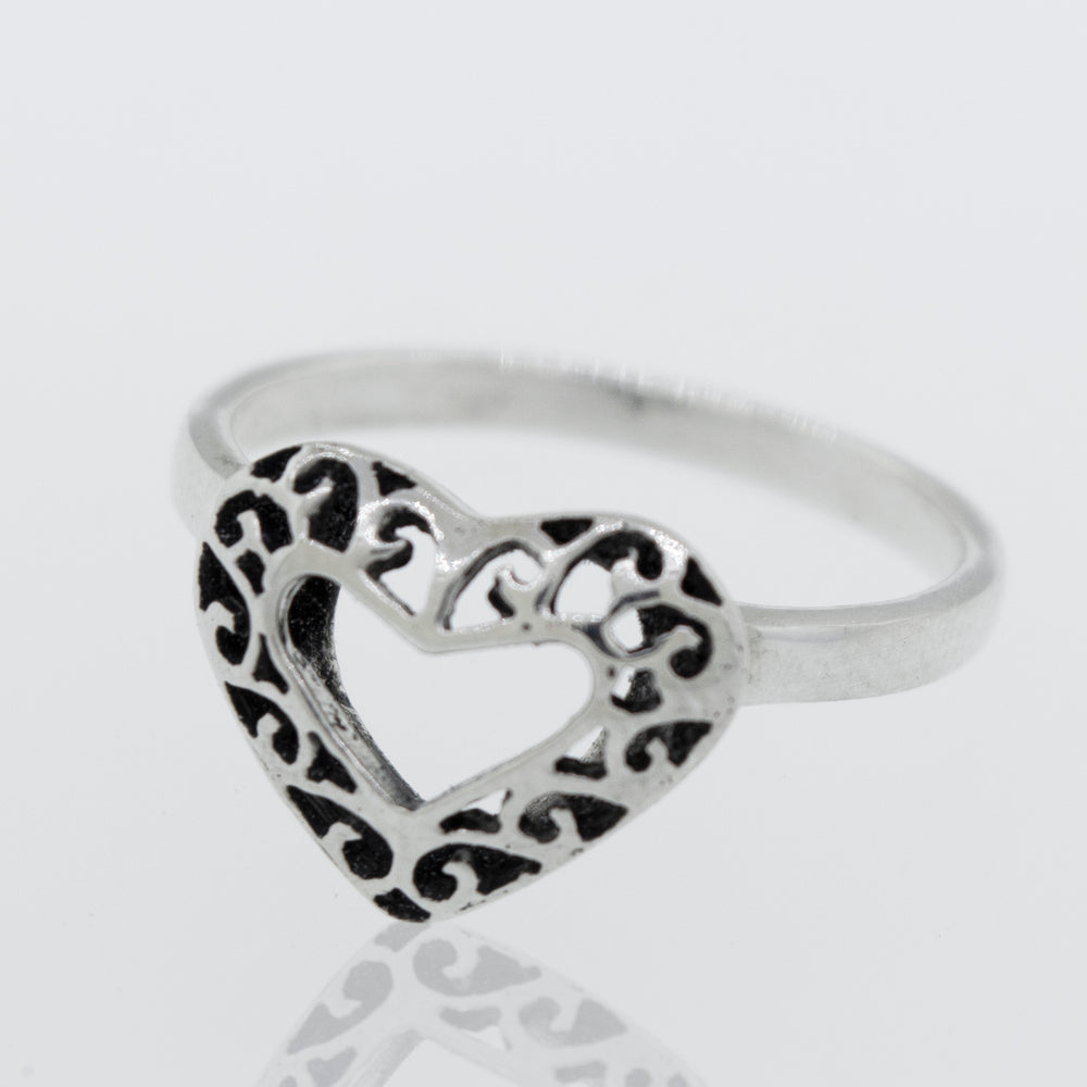 
                  
                    A minimalist Heart Shaped Ring with Filigree Detailing on a white surface.
                  
                