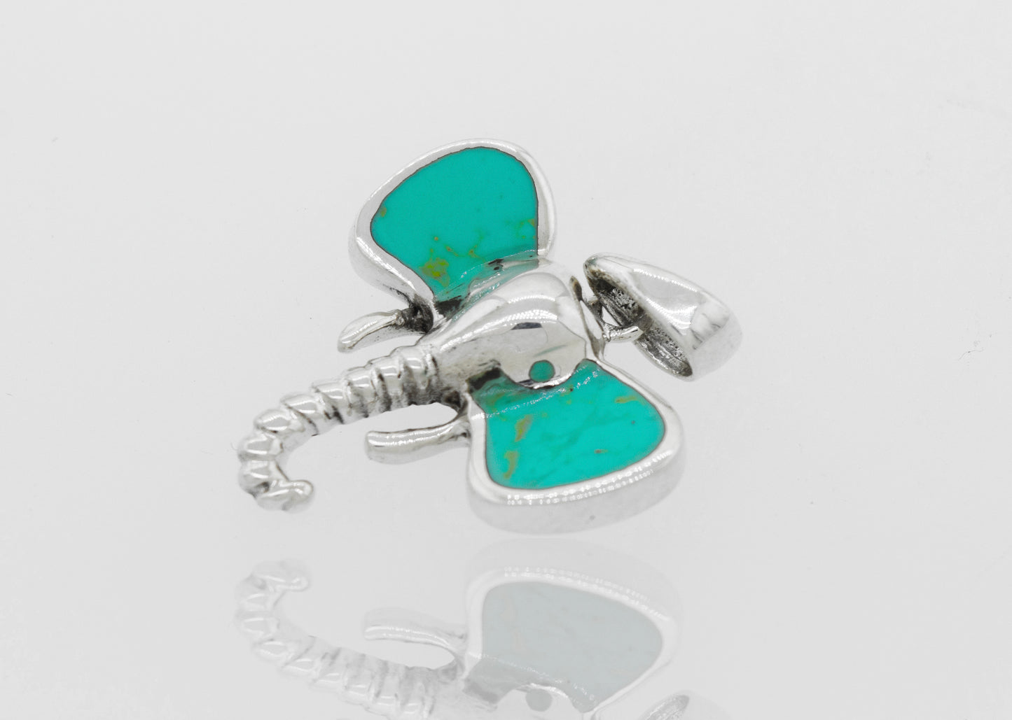 A Super Silver Elephant Head Pendant With Stone with inlaid stone ears and a turquoise stone.