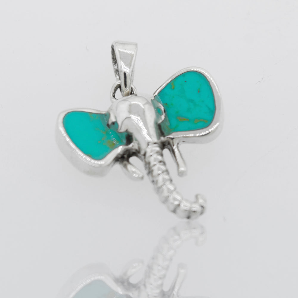 
                  
                    A Super Silver Elephant Head Pendant with inlaid turquoise stone ears.
                  
                