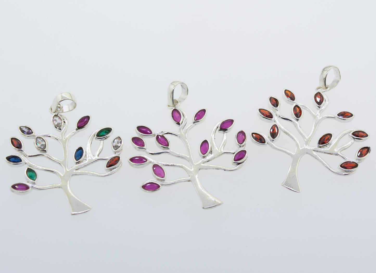Three Super Silver Tree of Life pendants adorned with faceted stone leaves.