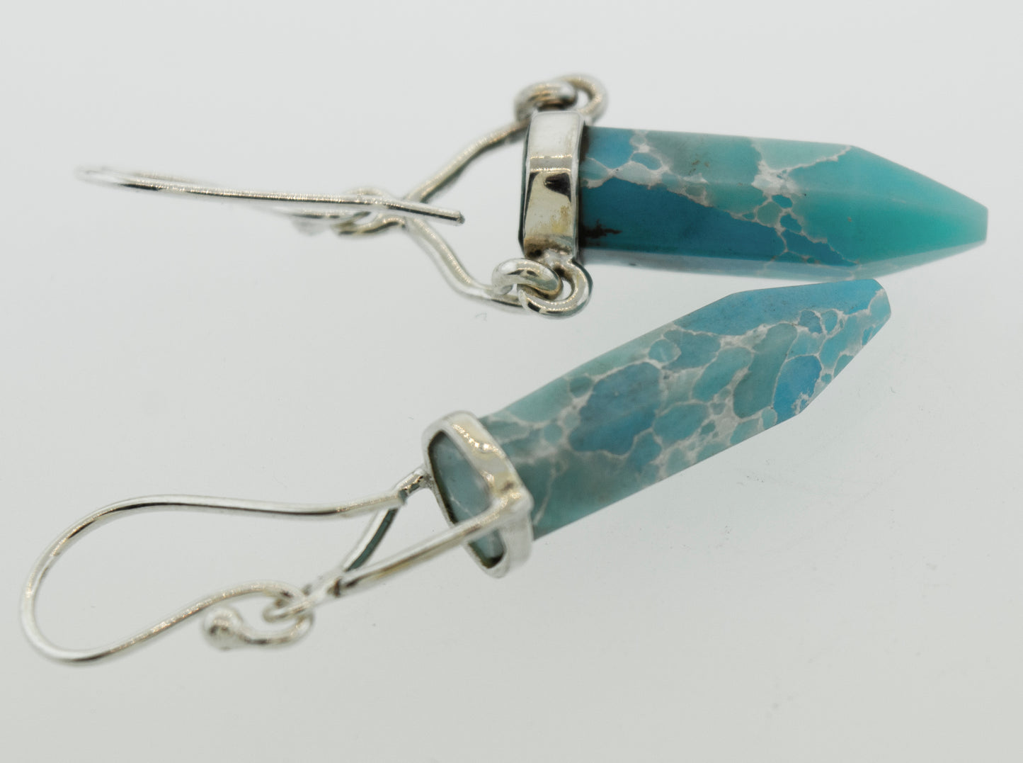 
                  
                    A pair of Super Silver Obelisk Shape Raw Larimar Earrings with french hooks.
                  
                