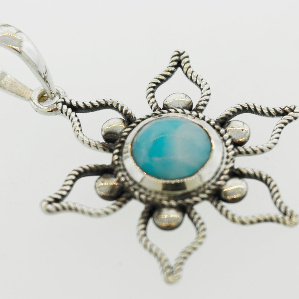A Larimar Flower Pendant from Super Silver with a turquoise stone is the perfect addition to your beach day outfit.