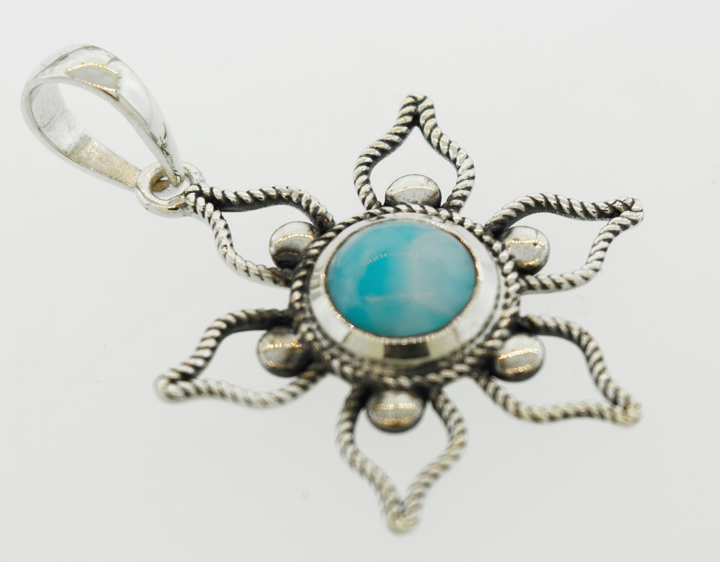A Larimar Flower Pendant from Super Silver with a turquoise stone is the perfect addition to your beach day outfit.