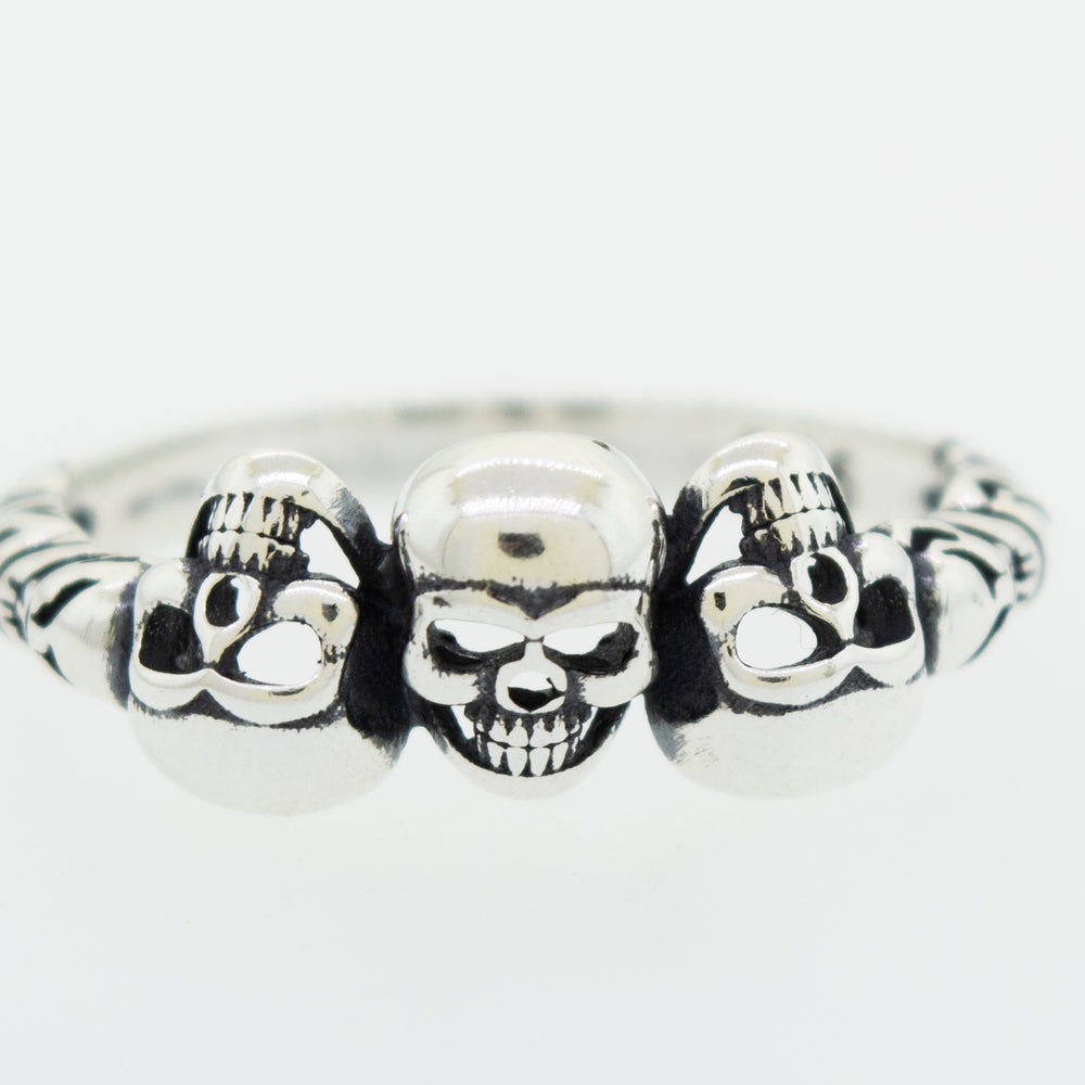 A gothic Three Skulls Ring featuring two skulls.