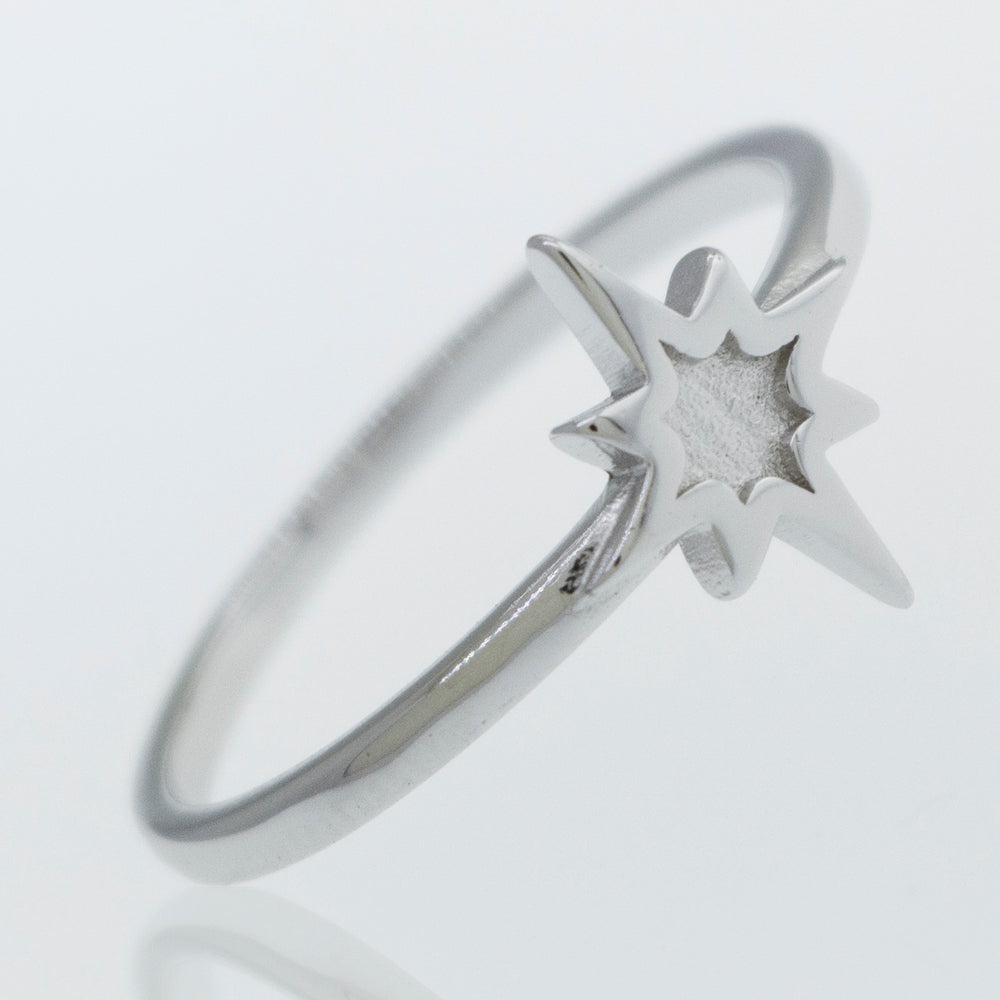 A Super Silver Twinkle Star Ring twinkles on a white surface.
