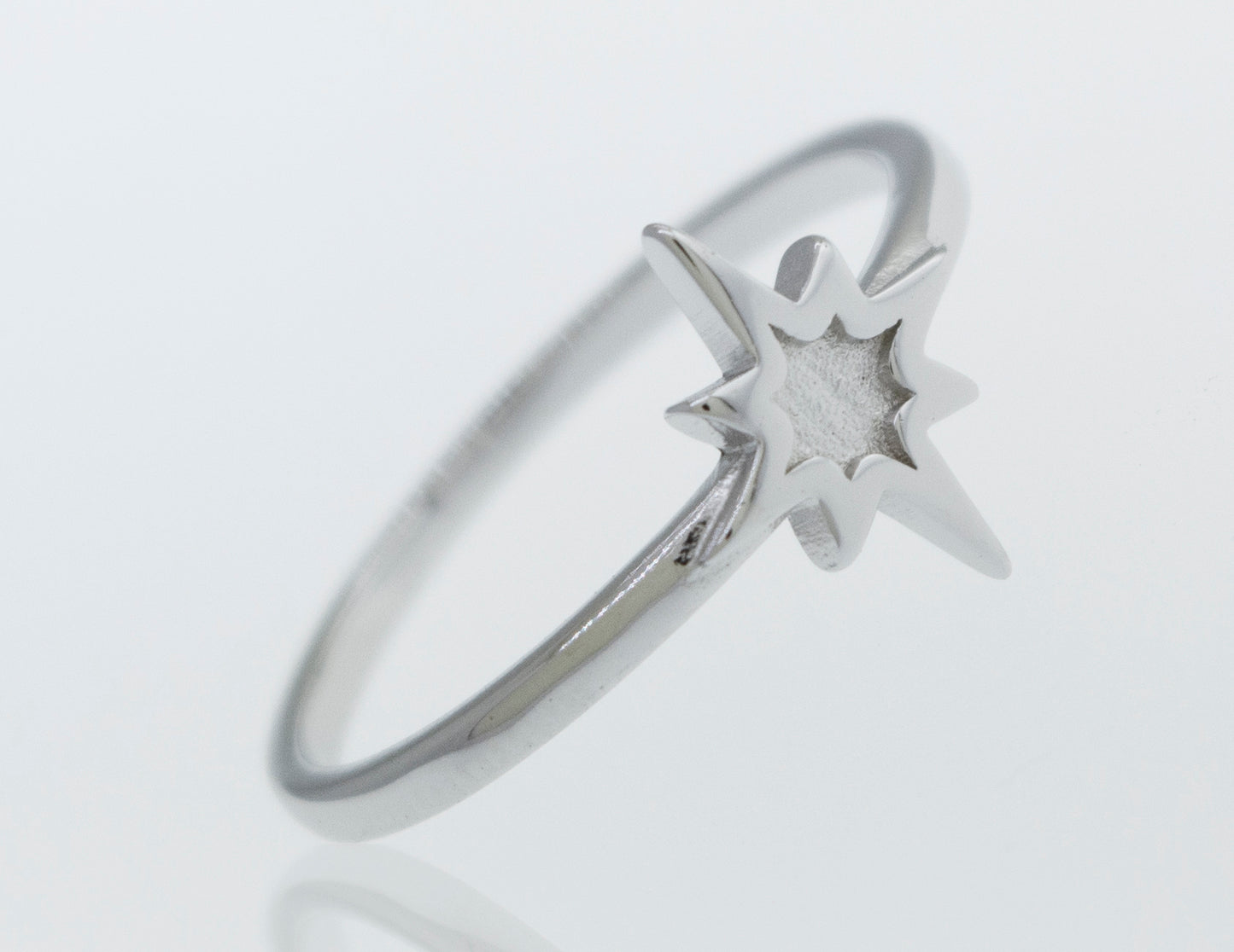 
                  
                    A Super Silver Twinkle Star Ring twinkles on a white surface.
                  
                