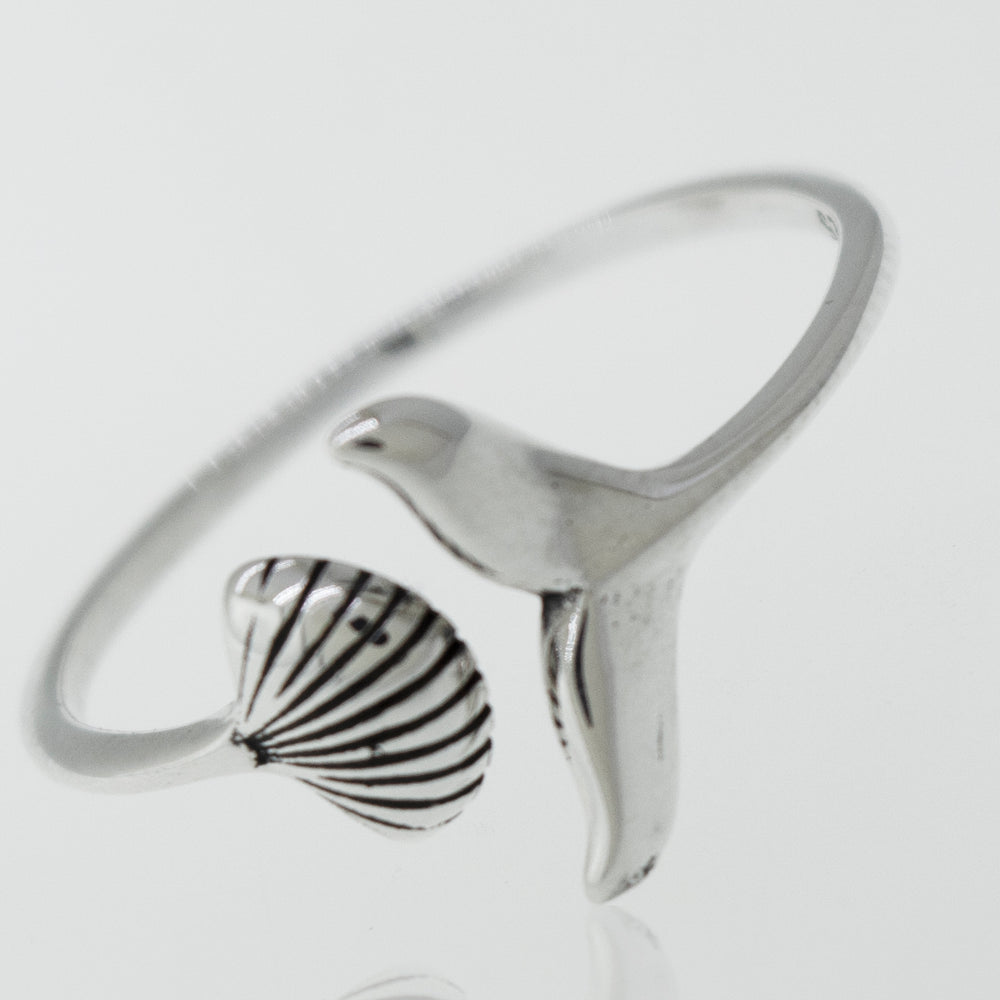 
                  
                    A Shark Tail and Seashell Ring from Super Silver with a seashell on it.
                  
                