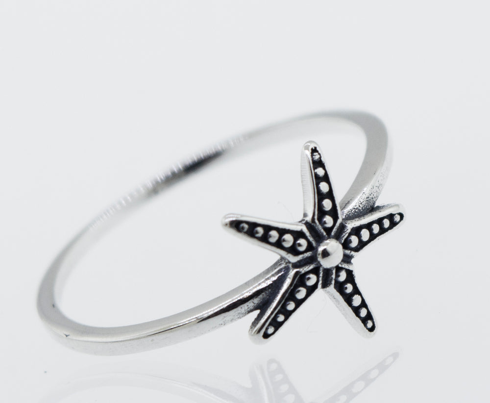 An oxidized Super Silver starfish ring on a white background.