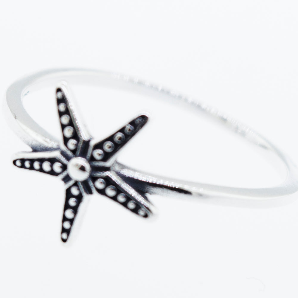 
                  
                    An oxidized Super Silver starfish ring on a white background.
                  
                