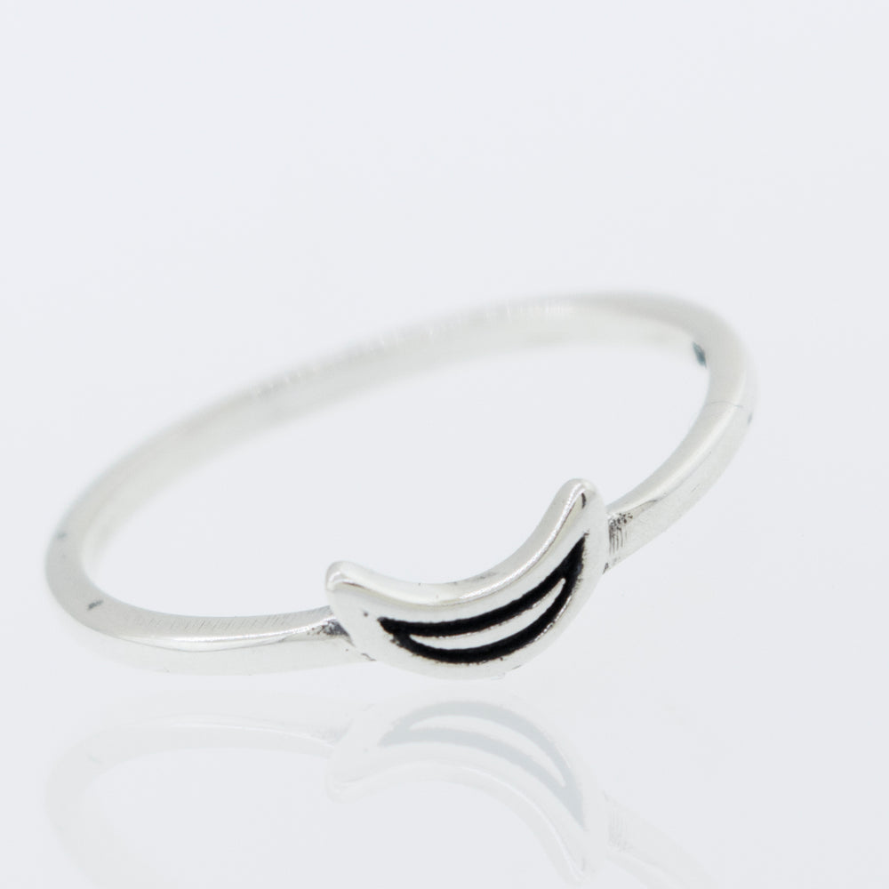 A Tiny Crescent Moon Ring with a smiley face on it.