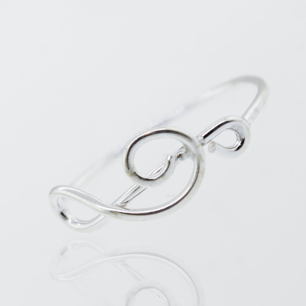 
                  
                    A high polish Super Silver Horizontal Treble Clef ring with a swirl design.
                  
                