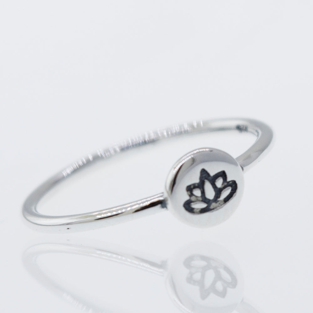 A modern stackable silver lotus ring with a minimalist lotus flower design.