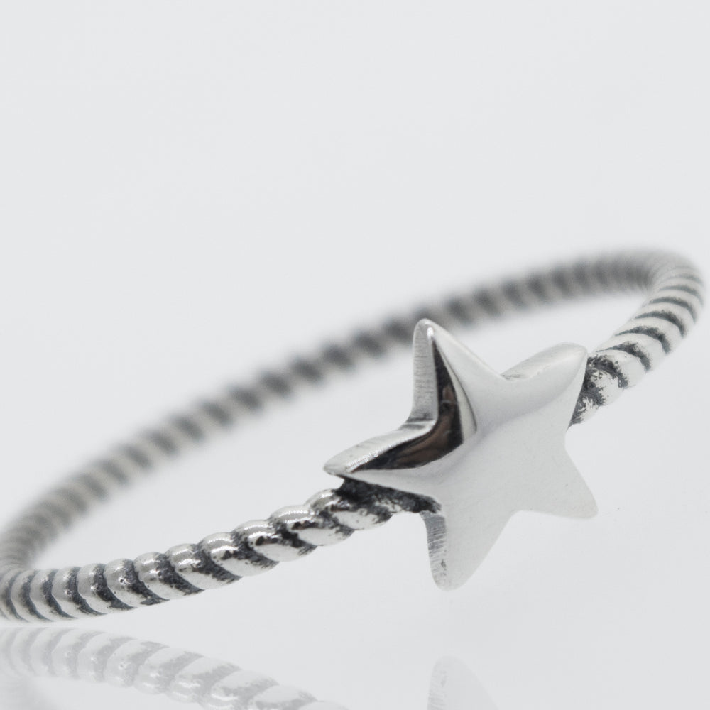An oxidized Super Silver star ring with a rope design band on a white background.