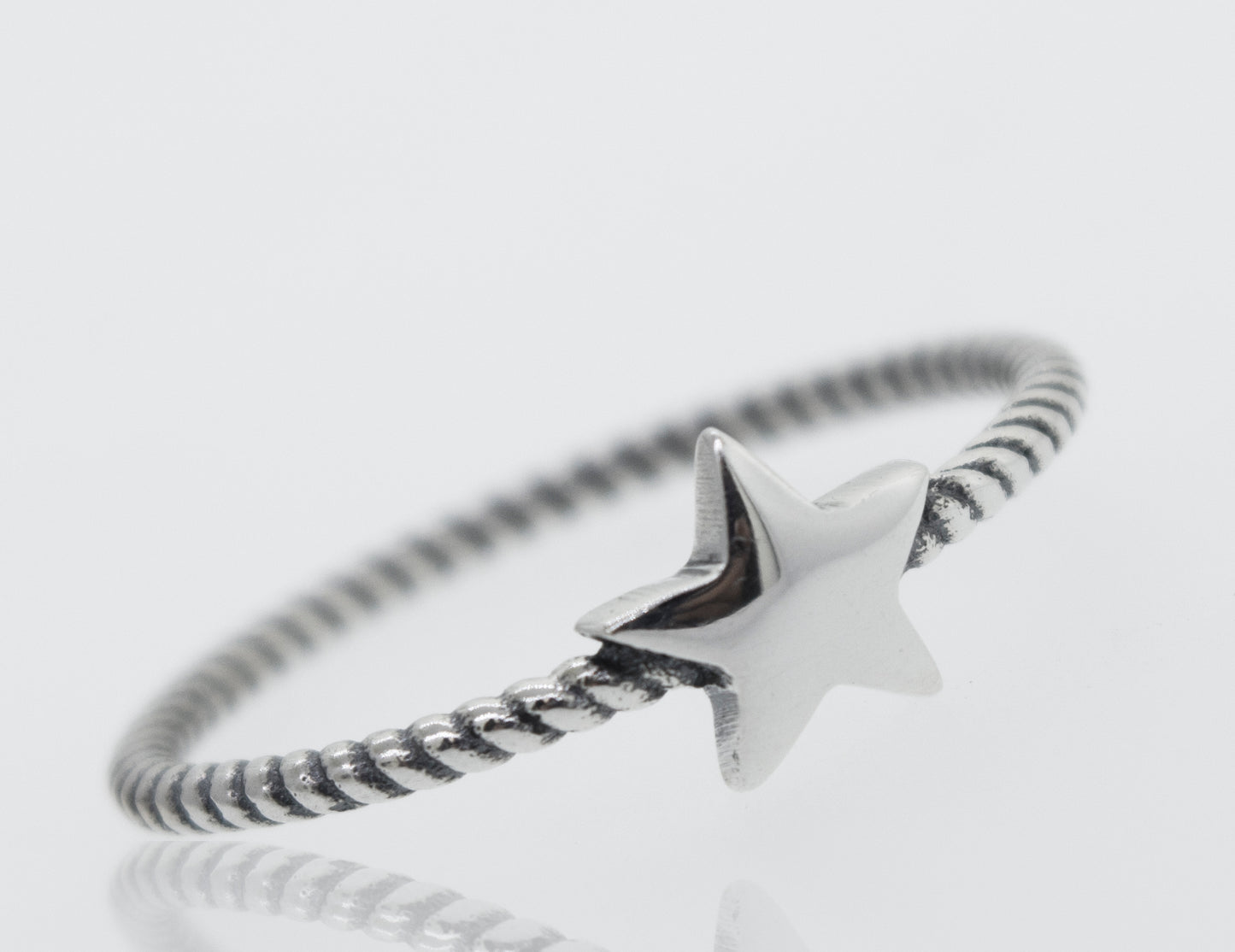 An oxidized Super Silver star ring with a rope design band on a white background.