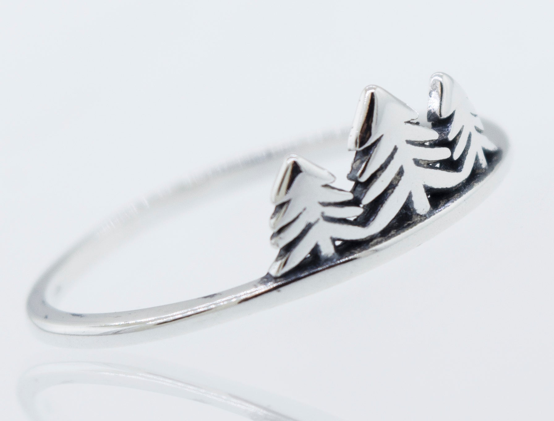 A minimalist silver Trees ring with delicate tree engravings, inspired by nature.