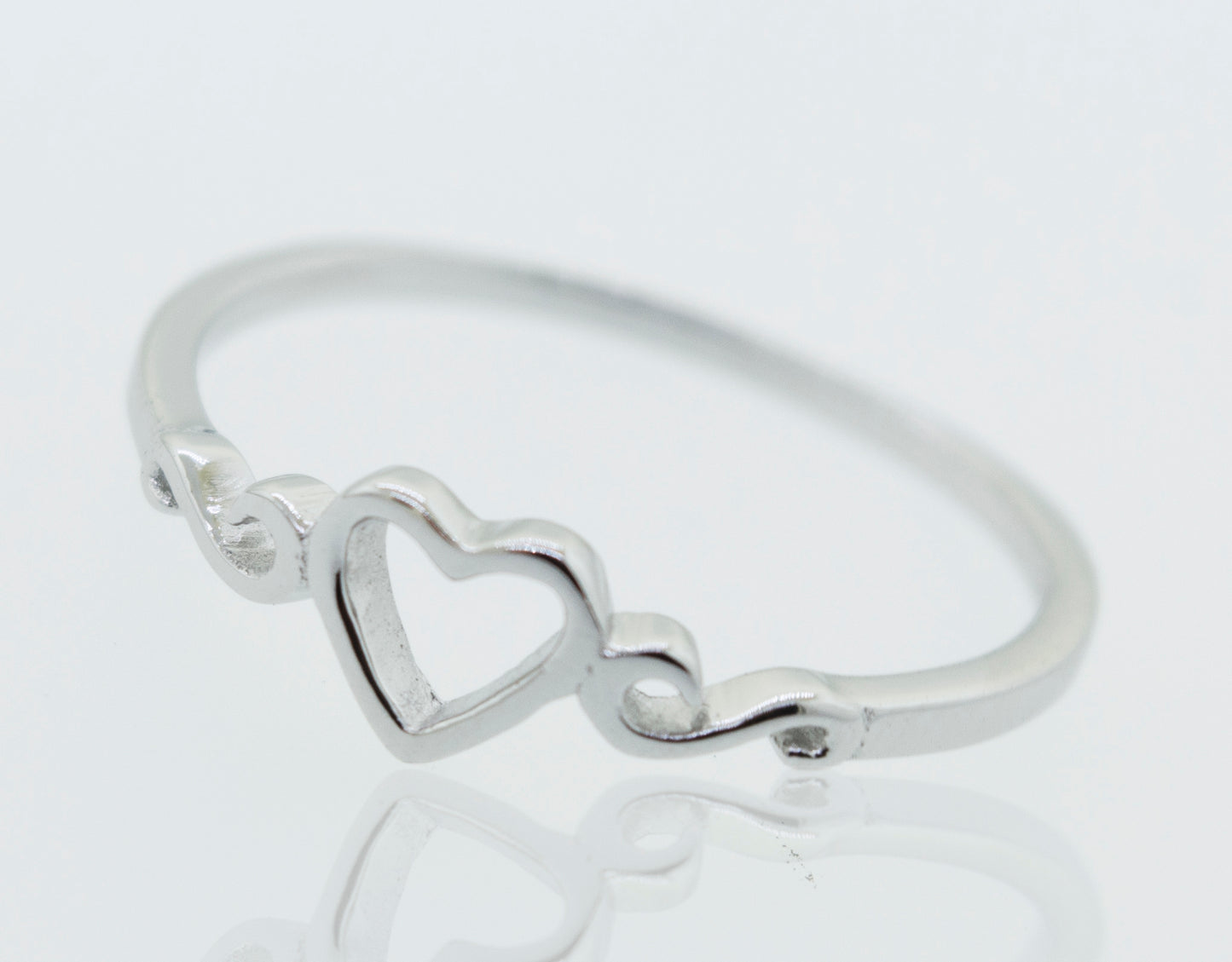A Simple Open Heart Ring on a white surface.
