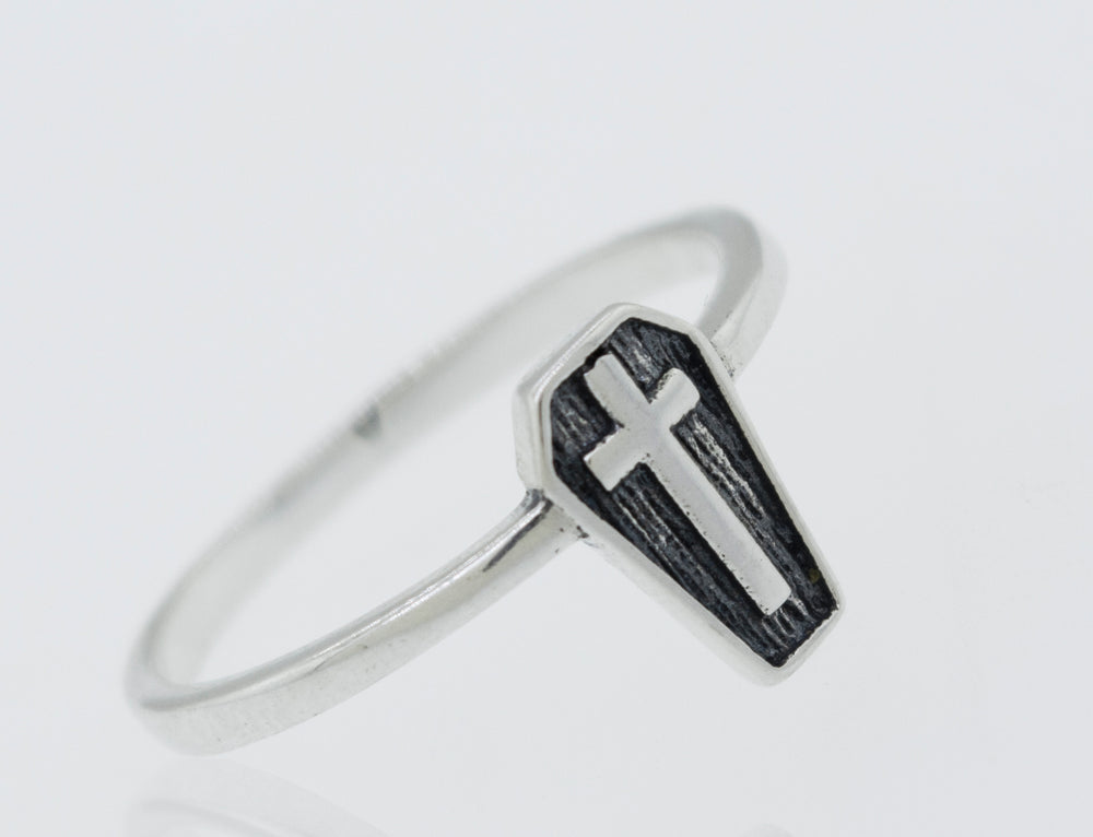 A silver Coffin Ring with a cross on it.
