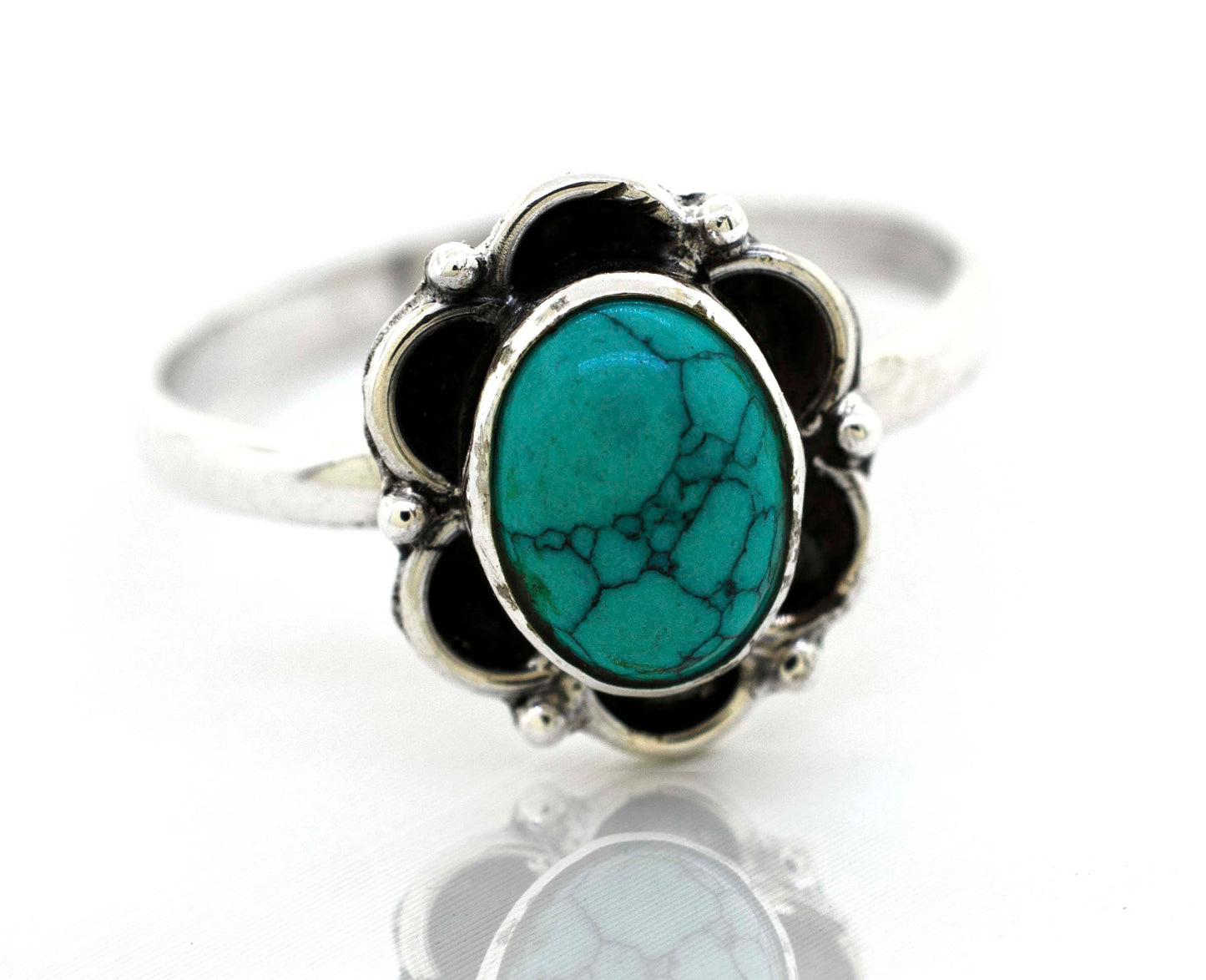 
                  
                    A delicate Super Silver gemstone ring with a central turquoise gemstone embraced by silver petals.
                  
                