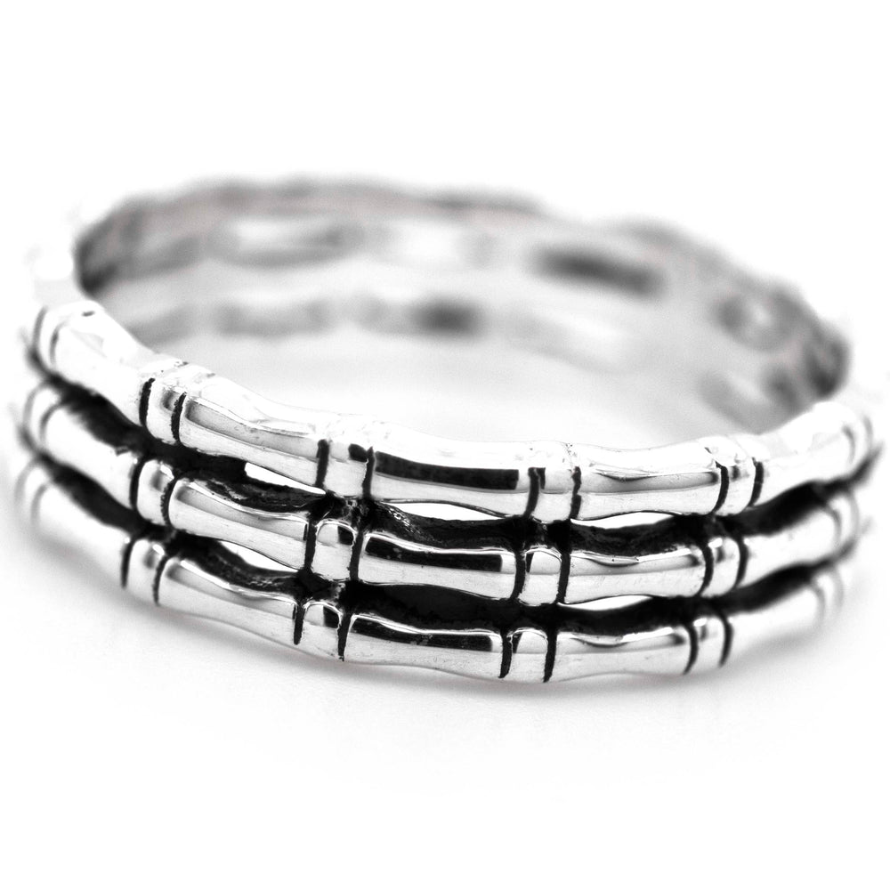 
                  
                    A minimalist stack of three Super Silver Triple Bamboo Band Rings with a bamboo design on a white background.
                  
                