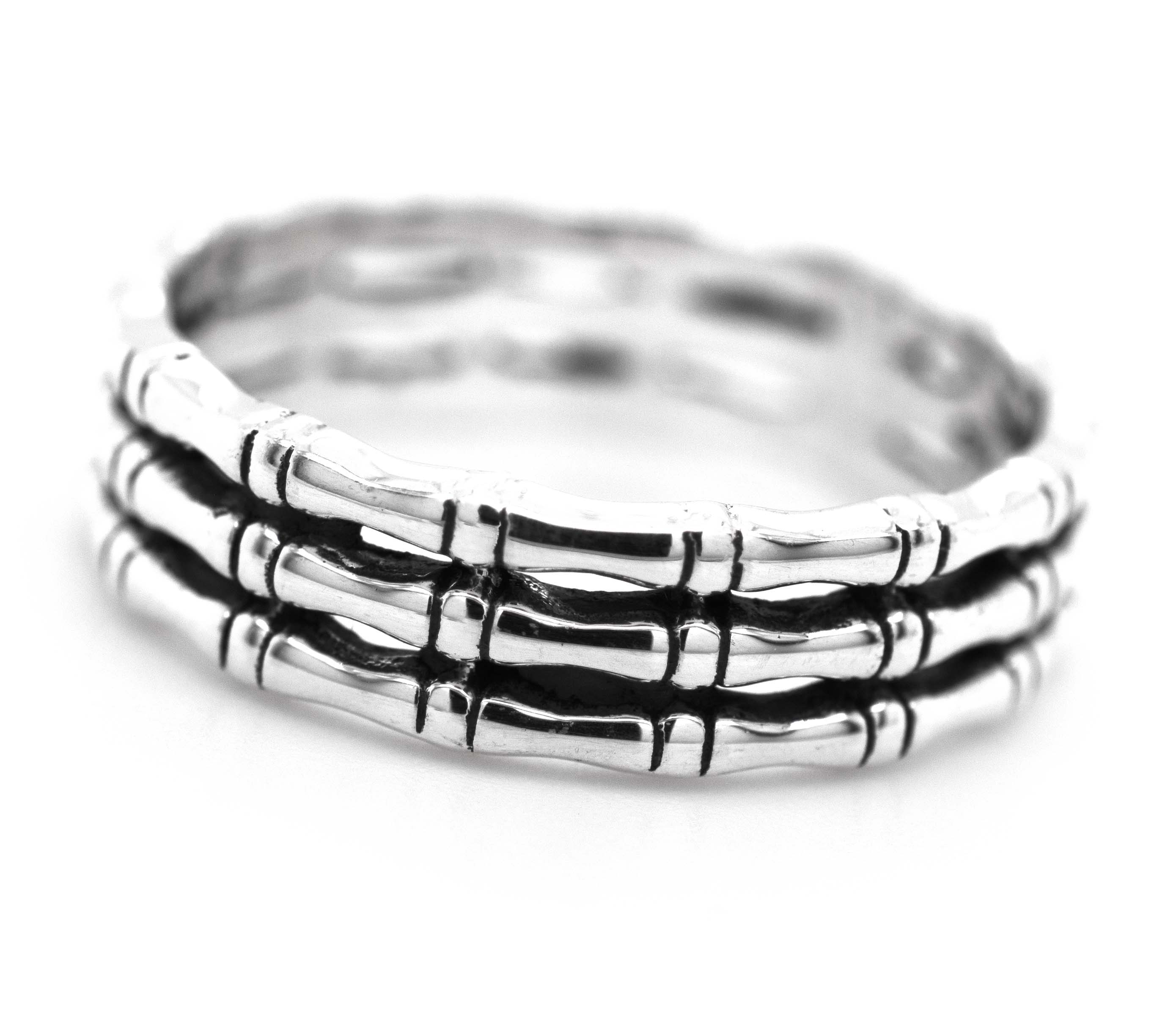 A minimalist stack of three Super Silver Triple Bamboo Band Rings with a bamboo design on a white background.
