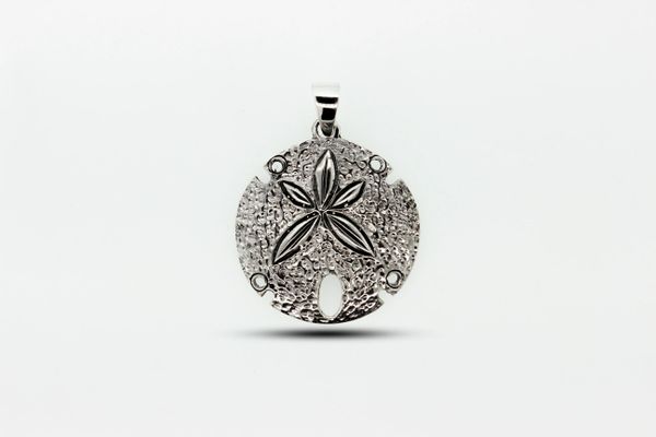 
                  
                    A Super Silver Sand Dollar Pendant With Textured Surface with a hammered finish and an ornate design on it.
                  
                