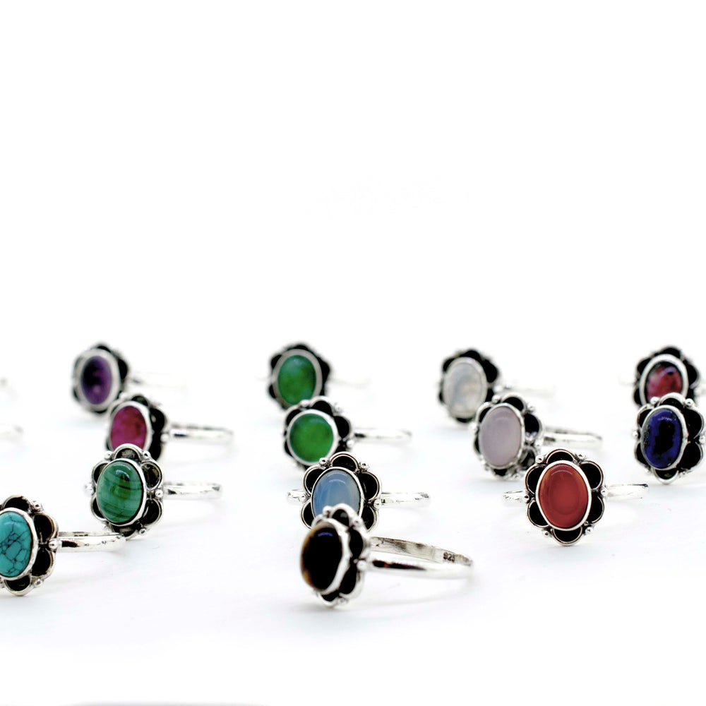 
                  
                    A group of colorful Gemstone Rings With Oxidized Flower Design on a white background.
                  
                